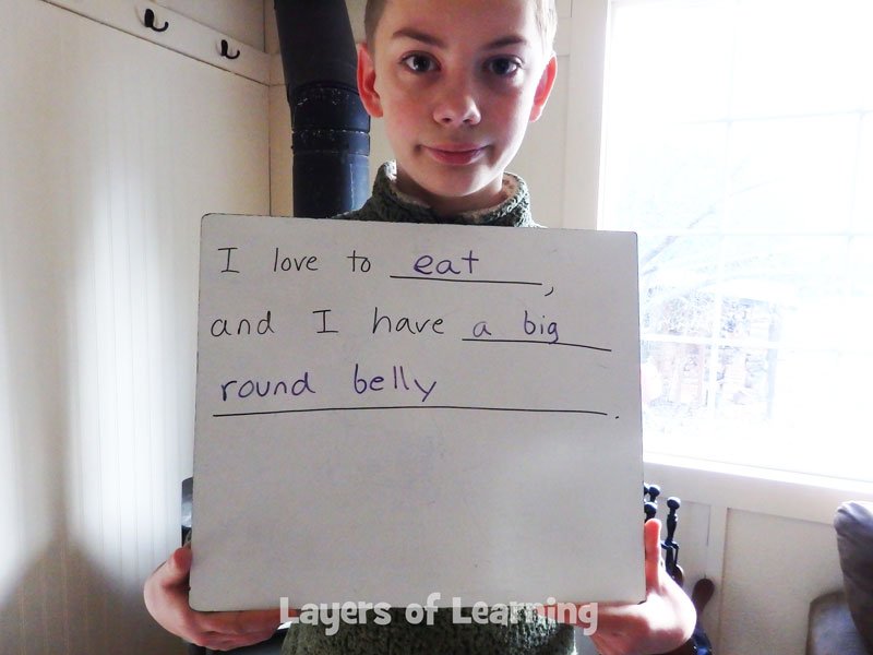 Child holding up a sentence he wrote